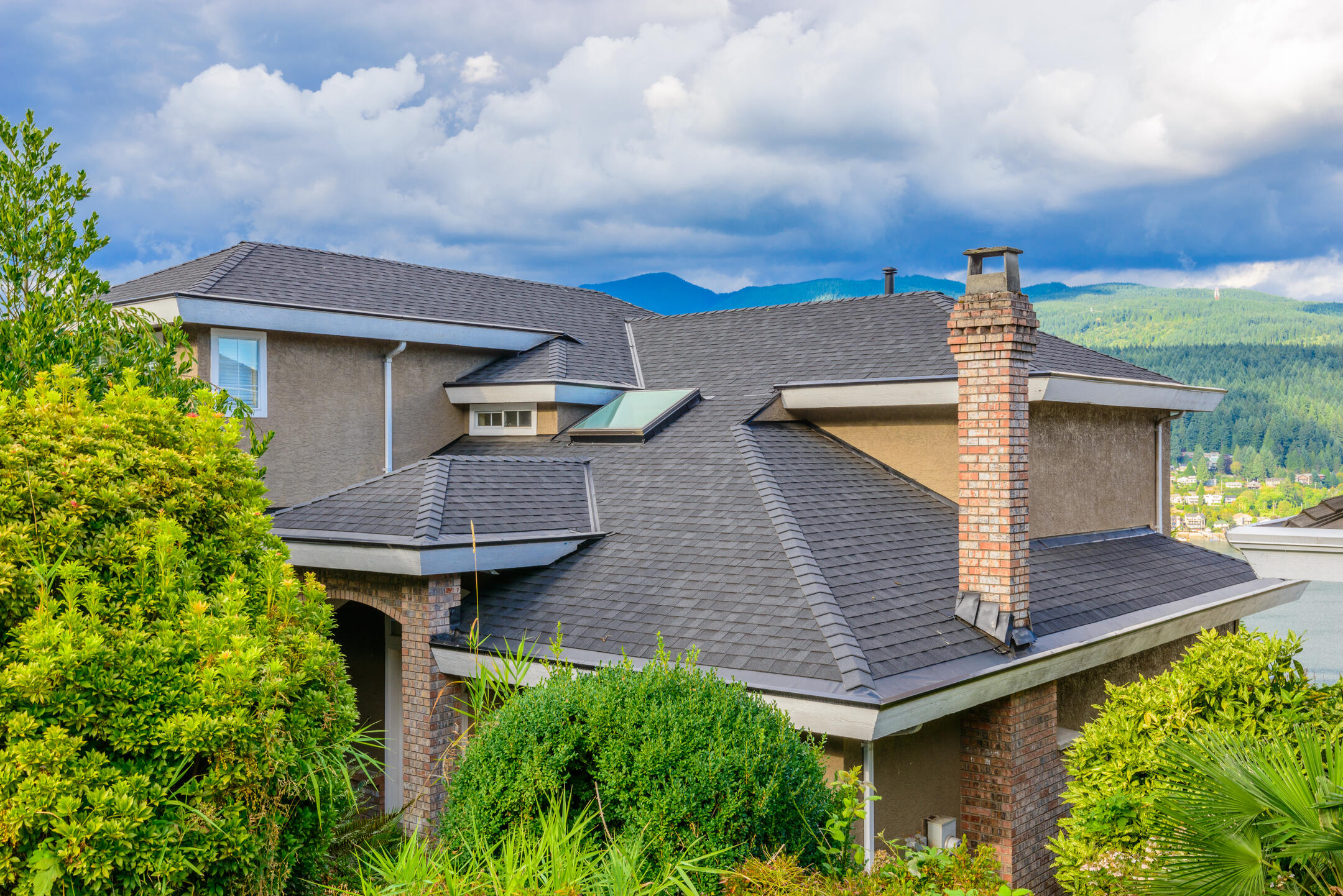 best roof shingles-home with new gray shingles with mountains in background